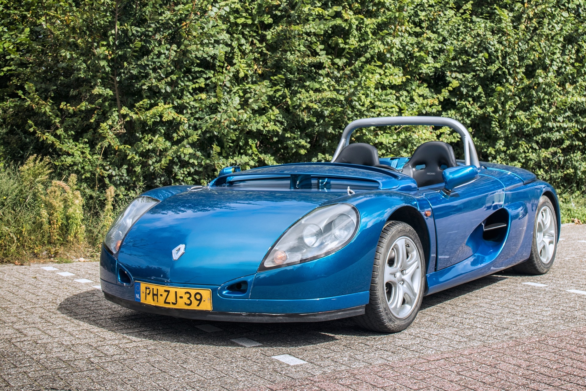 Blauwe Renault Sport Spider uit 1996 op een parkeerplaats